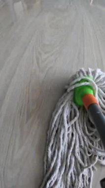 Evdeki paspasla ahşap kaplamaları temizliyorum, yakın plan. POV görünümü