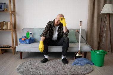 Ev işleri konsepti. Temizlik yapmaktan sıkılmış adam, boşluğu kopyala