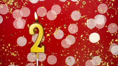 Altın yanan mum iki numara. Kırmızı arkaplanda 2 yazılı doğum günü tebrik kartı konfeti ve simle. Yıldönümü, kutlama etkinliği ve doğum günü konsepti.