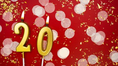 Altın yanan mum numarası 20. Kırmızı arkaplanda 20 yazılı konfeti ve simle doğum günü tebrik kartı. Yıldönümü, kutlama etkinliği ve doğum günü konsepti.