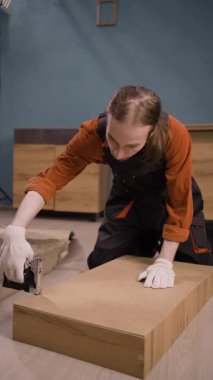 Mobilya montaj işlemi, erkek derleyici zımba kullanarak kabine parçalarını kuruyor. Yakın plan.