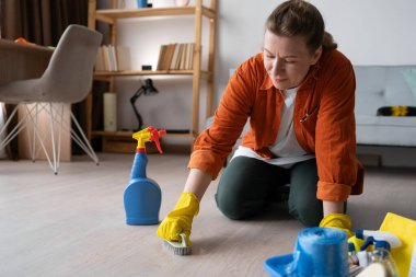 Ev işleri, temizlik ve ev temizliği konsepti. Sarı lastik eldivenli bir kadın fırçayla yerleri fırçalayacak. Boşluğu kopyala