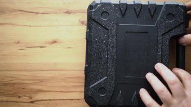Erkek ellerinin kablosuz tornavidayla açtığı kutuyu kapat. İnşa aracı konsepti. Üst görünüm