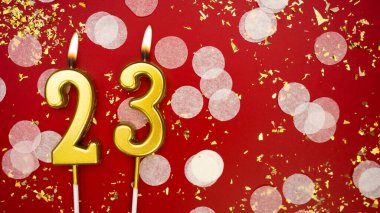 Altın yanan mum numarası yirmi üç. Kırmızı arka planda 23 yazısıyla birlikte konfeti ve simle birlikte doğum günü tebrik kartı. Yıldönümü, kutlama etkinliği ve doğum günü konsepti.