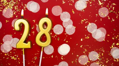 Yanan altın mum numarası 28. Kırmızı arkaplanda 28 yazılı konfeti ve simle doğum günü tebrik kartı. Yıldönümü, kutlama etkinliği ve doğum günü konsepti.