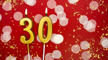 Altın yanan mum numarası 30. Kırmızı arkaplanda 30 yazılı doğum günü tebrik kartı konfeti ve simle. Yıldönümü, kutlama etkinliği ve doğum günü konsepti.