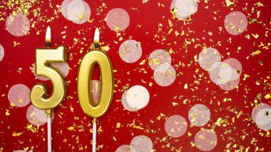 Altın yanan mum numarası 50. Kırmızı arkaplanda 50 yazılı doğum günü tebrik kartı konfeti ve simle. Yıldönümü, kutlama etkinliği ve doğum günü konsepti.