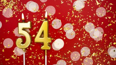 Elli dört numaralı altın yanan mum. Kırmızı zemin üzerinde 54 yazısıyla konfeti ve simle birlikte doğum günü tebrik kartı. Yıldönümü, kutlama etkinliği ve doğum günü konsepti.