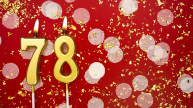 Altın yanan mum numarası 78 'di. Kırmızı zemin üzerinde 78 yazısıyla konfeti ve simle birlikte doğum günü tebrik kartı. Yıldönümü, kutlama etkinliği ve doğum günü konsepti.