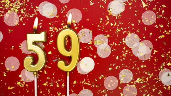Altın yanan mum numarası 59 'du. Kırmızı arkaplanda 59 yazılı doğum günü tebrik kartı konfeti ve simle. Yıldönümü, kutlama etkinliği ve doğum günü konsepti.