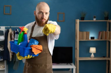 Temizlik sepetiyle gelen hademe, evdeki oturma odasında durduğun için kızgın ve sorumluluk sahibi. Boşluğu kopyala