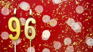 Altın yanan mum numarası 96 'ydı. Kırmızı arka planda 96 yazısıyla konfeti ve simle birlikte doğum günü tebrik kartı. Yıldönümü, kutlama etkinliği ve doğum günü konsepti.