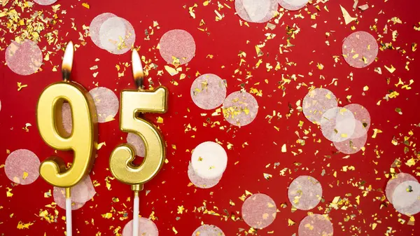 Altın yanan mum numarası doksan beş. Kırmızı arkaplanda 95 yazılı doğum günü tebrik kartı konfeti ve simle. Yıldönümü, kutlama etkinliği ve doğum günü konsepti.