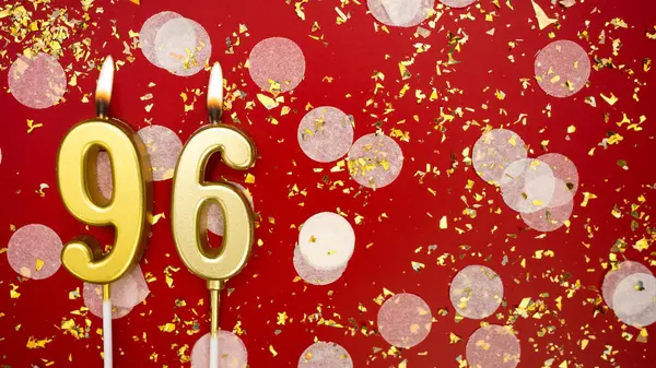 Altın yanan mum numarası 96 'ydı. Kırmızı arka planda 96 yazısıyla konfeti ve simle birlikte doğum günü tebrik kartı. Yıldönümü, kutlama etkinliği ve doğum günü konsepti.
