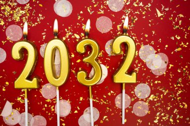 Mutlu yıllar 2032. Tatil geçmişi. 2032 yılının sayıları kırmızı arka planda konfeti ve simle altın mum yakmaktan. Yeni yıl tatili kavramı. Boşluğu kopyala