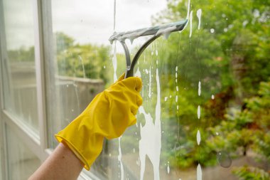 Pencereleri paspasla temizleyin. Ev temizliği kavramı
