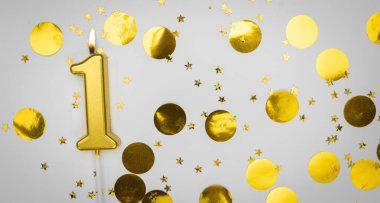 Beyaz arka planda altın konfeti ve sim ile bir numaralı yanan doğum günü mumu. Bir yaşında. Doğum günün kutlu olsun. Şenlik arka planında bir kart. Pankart