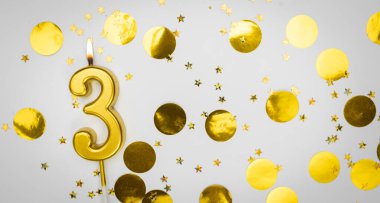 Beyaz arka planda altın konfeti ve sim ile 3 numaralı yanan doğum günü mumu. Üç yaşında. Doğum günün kutlu olsun. Geçmiş şenliği kartı. Bayrak