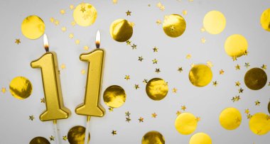 Beyaz arka planda altın konfeti ve simle 11 numaralı yanan doğum günü mumu. On bir yaşında. Doğum günün kutlu olsun. Geçmiş şenliği kartı. Bayrak