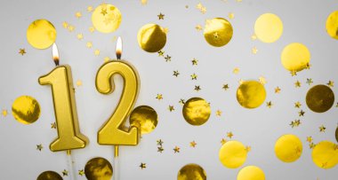 Beyaz arka planda altın konfeti ve simle 12 numaralı yanan doğum günü mumu. On iki yaşında. Doğum günün kutlu olsun. Geçmiş şenliği kartı. Bayrak