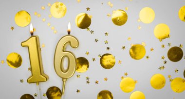 Beyaz arka planda altın konfeti ve simle birlikte 16 numaralı yanan doğum günü mumu. On altı yaşında. Doğum günün kutlu olsun. Geçmiş şenliği kartı. Bayrak