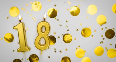 18 numaralı yanan doğum günü mumu beyaz arka planda altın konfeti ve sim ile. On sekiz yaşında. Doğum günün kutlu olsun. Geçmiş şenliği kartı. Bayrak