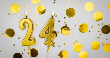 24 numaralı yanan doğum günü mumu beyaz arka planda altın konfeti ve sim ile. Yirmi dört yaşında. Doğum günün kutlu olsun. Geçmiş şenliği kartı. Bayrak