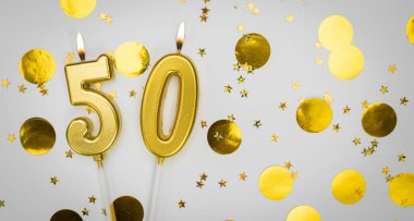 Beyaz arka planda, altın konfeti ve simle birlikte 50 numaralı yanan doğum günü mumu. Elli yaşında. Doğum günün kutlu olsun. Geçmiş şenliği kartı. Bayrak