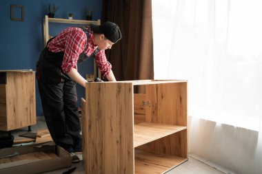 Kadın Profesyonel Mobilya Toplayıcısı Tulumlular ile Evdeki Ahşap Dolapları Birleştiriyor. Uzayı kopyala Mobilya montaj konsepti