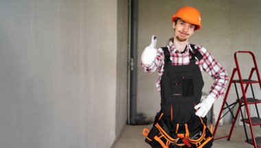 Sarı başlıklı genç müteahhit güzel jest yapıyor. Boşluğu kopyala