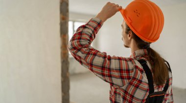 Bitmemiş binadaki inşaat şirketinin dikiz aynasından. İnşaat işçisi. Pankart. Boşluğu kopyala