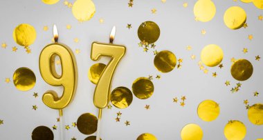 97 numara konfeti arkaplanlı beyaz üzerine doğum günü mumu. Doksan yedi yıllık doğum günü. Doğum günü ve yıldönümü kutlaması kavramı. Boşluğu kopyala.