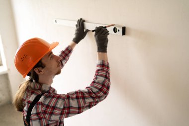 İnşaat işçisi, duvar hizasını özel seviyeye ayarlıyor. Boşluğu kopyala