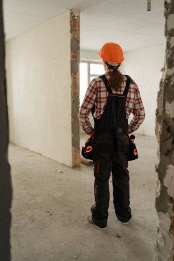 Ev geliştirme ve inşaat konsepti. Sarı miğferli erkek inşaat işçisinin dikiz görüşü başka yöne bakıyor. Boşluğu kopyala