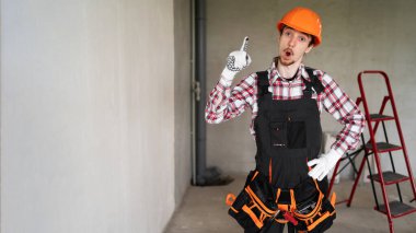 Heyecanlı yetenekli inşaatçının portresi harika bir fikir ve şantiyede duran Eureka jestini gösteriyor. Boşluğu kopyala