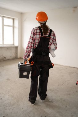Profesyonel tamircinin ya da tamircinin elinde alet çantasıyla evde dikilmesinin arkası. Boşluğu kopyala
