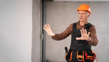 Kes jesti. İnşaatçı. İnşaat binasında miğferli yaşlı bir inşaat işçisi. İnşaat işçisi. Boşluğu kopyala