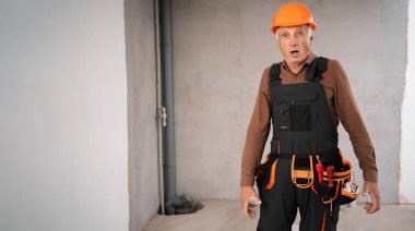 Meslek, inşaat ve inşaat kavramı. Şok olmuş kıdemli işçi ya da miğferli müteahhit şantiyedeki yüz ifadesine hayran kaldı. Boşluğu kopyala