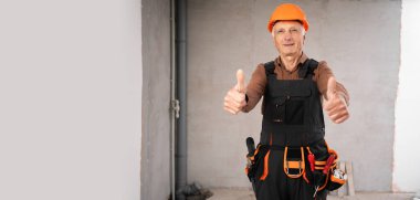 Miğferli yaşlı, olgun bir müteahhit inşaat alanında onay veriyor. meslek, inşaat ve inşaat kavramı