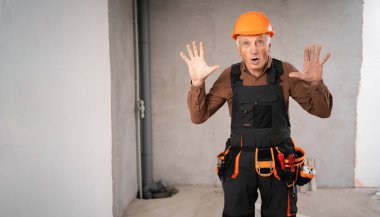 Güvenlik kaskı takmış yaşlı erkek müteahhit kameraya 10 parmak doğrultuyor. Meslek, inşaat ve inşaat konsepti. Boşluğu kopyala