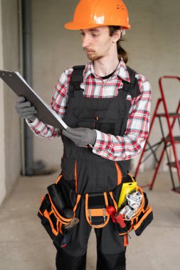 İnşaat alanında çalışan koruyucu miğferli bir inşaat işçisi. Uzayı kopyala Ev yenilenmesi