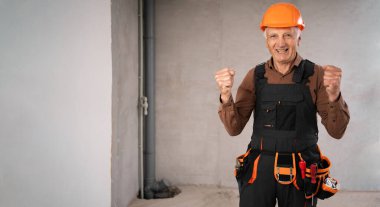 Meslek, inşaat ve inşaat kavramı. Başarıyı kutlayan ve şantiyede kazanan üst düzey işçi ya da miğfer takan inşaatçı. Boşluğu kopyala