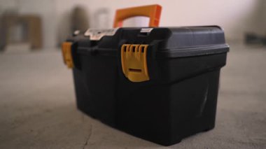 Kadın ellerini alet çantasının kilidini açarken kapat. Plastik kutu tutan kadın işçi. Alet çantalı tamirci. Boşluğu kopyala