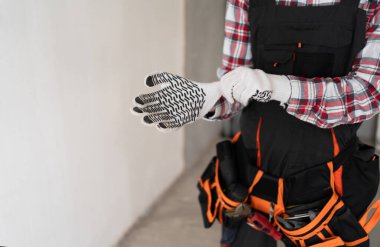 İş eldivenlerini takan inşaatçı ellerini kapatın. İnşaat alanı ve bina konsepti. Boşluğu kopyala