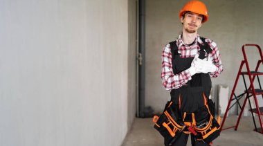 Genç ustabaşı ya da inşaatçı elleri göğsünde, yüzünde minnet ifadesi olan. Boşluğu kopyala