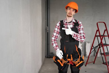 İnşaat alanındaki inşaatçı reklam için mekânda el kol hareketi yapıyor. Boşluğu kopyala