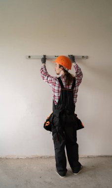 İnşaat işçisi duvarları ruh seviyesiyle, dikiz görüşüyle ölçer. Boşluğu kopyala