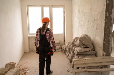 Eski bir apartmanda, bir odayı yenilemeye hazırlanan bir inşaatçının dikiz görüntüsü. Boşluğu kopyala
