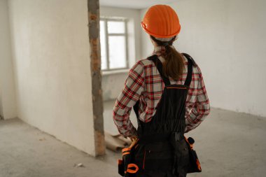 İnşaatçının ya da inşaat işçisinin eski daireye baktığı arka manzara. Ev geliştirme konsepti.