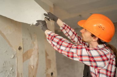 Duvardan eski duvar kağıtlarını kaldıran bir müteahhit yenileme ve iç yenileme için bir daire hazırlar. Yakın plan.